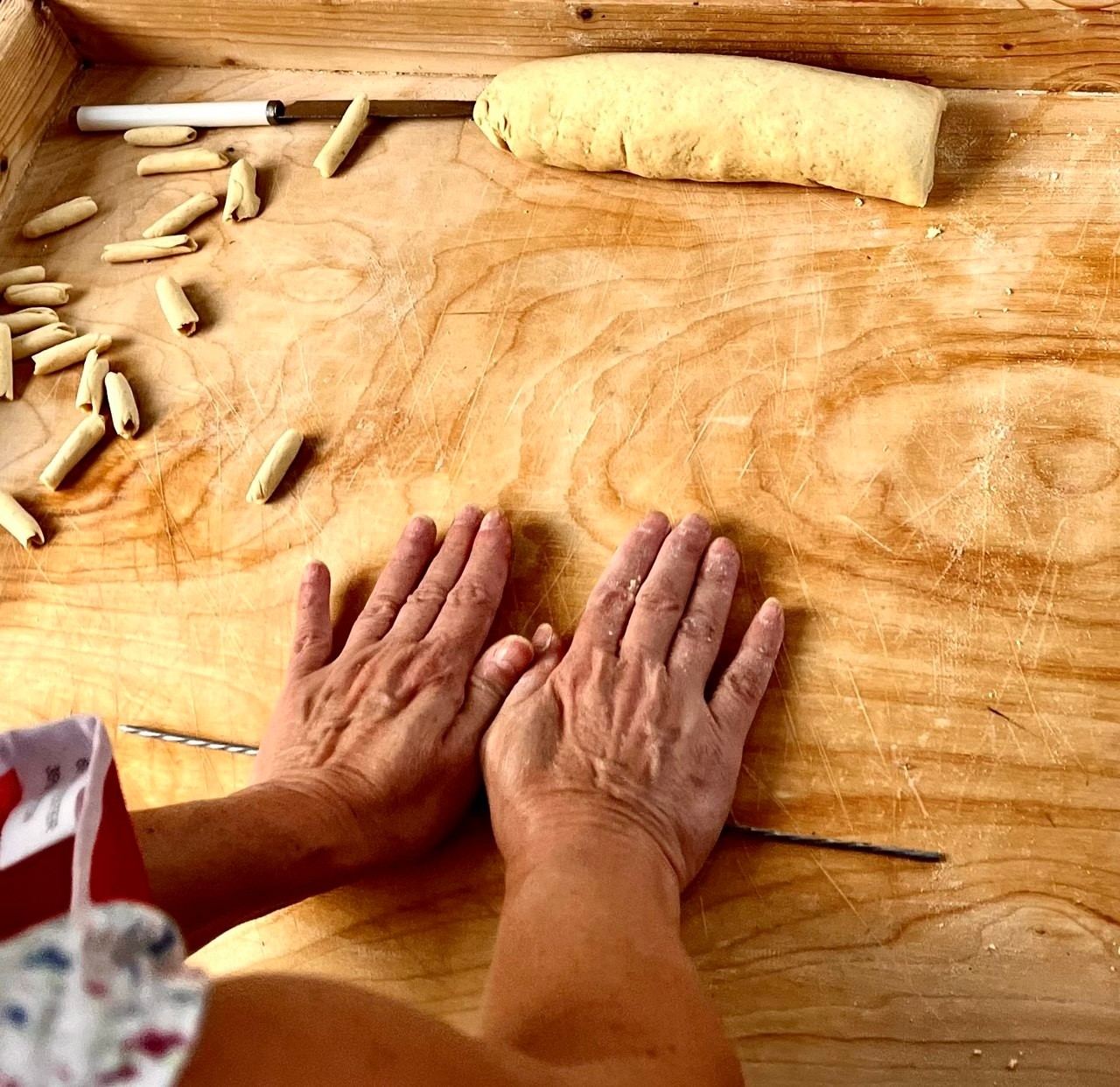Mani che impastano le orecchiette durante un laboratorio di cucina